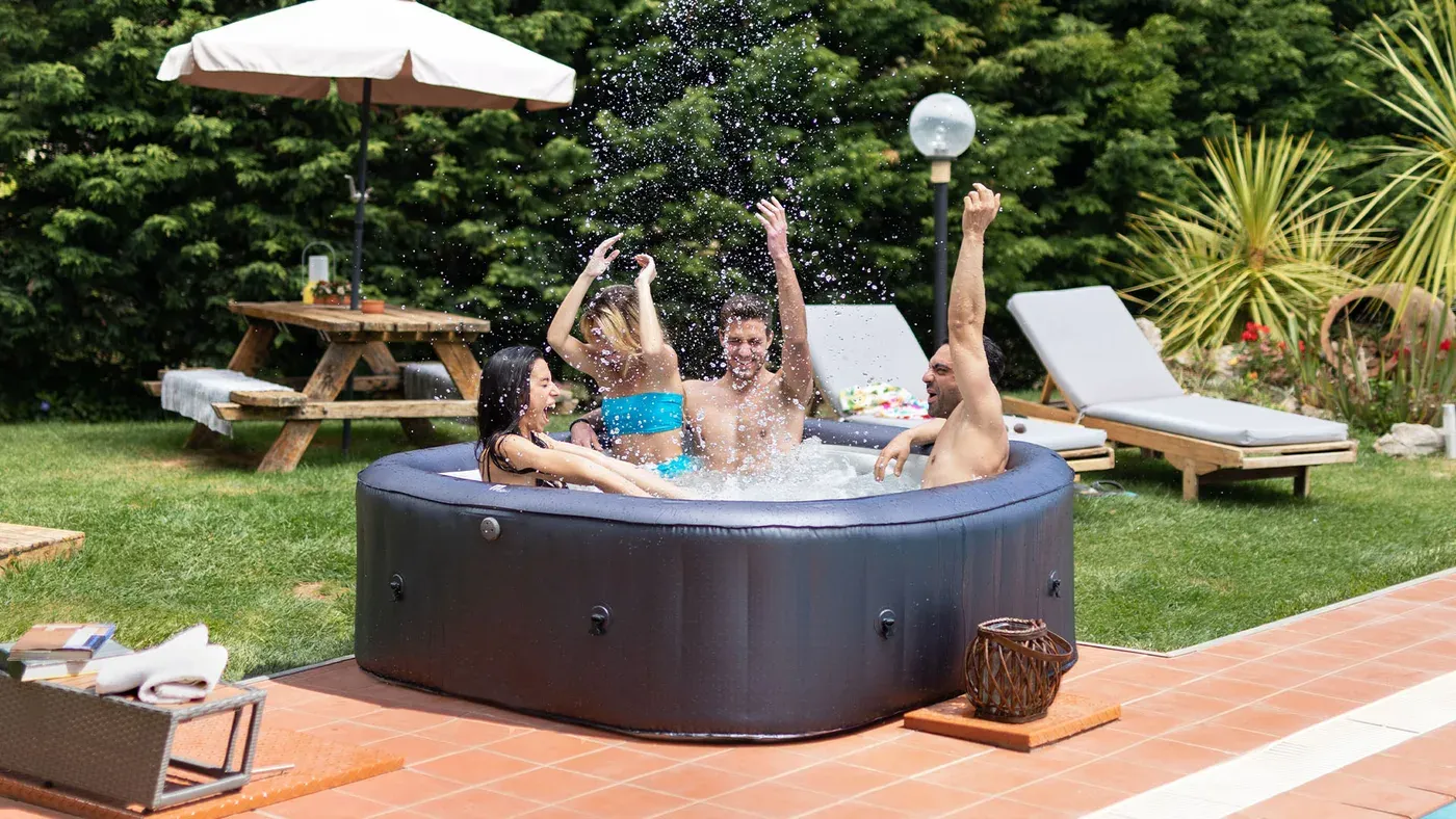 Quatre adultes assis dans le MSpa Muse Otium installé sur une terrasse carrelée